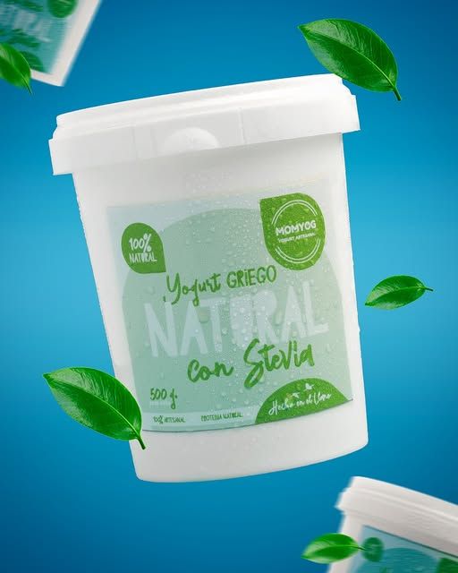 Envase de yogur griego natural con hojas verdes sobre fondo turquesa